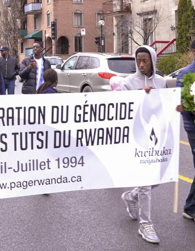 Un groupe de personnes marchant dans la rue avec un bannière sur laquelle on peut lire « Commémoration du génocide contre les Tutsi du Rwanda. Avril-Juillet 1994. www.pagerwanda.ca ». Visibilité masquée.